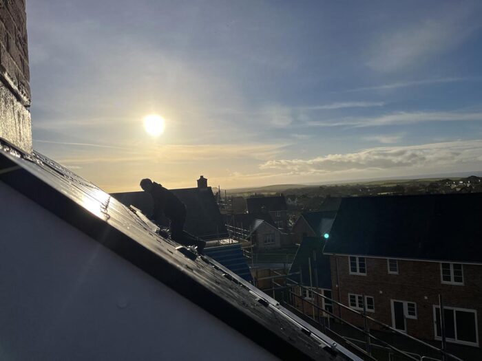 Solar panels fitted by Island Renewables with the sun setting behind